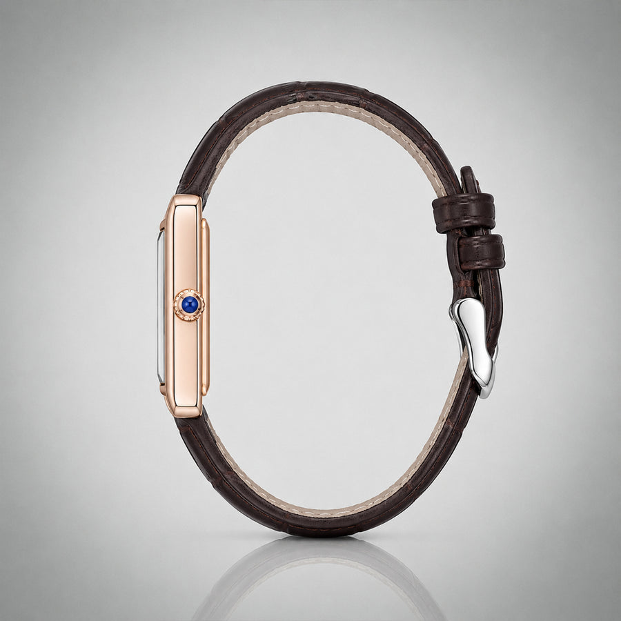Side profile of the 1927 gold tank case with blue cabochon crown and brown leather strap — architectural view