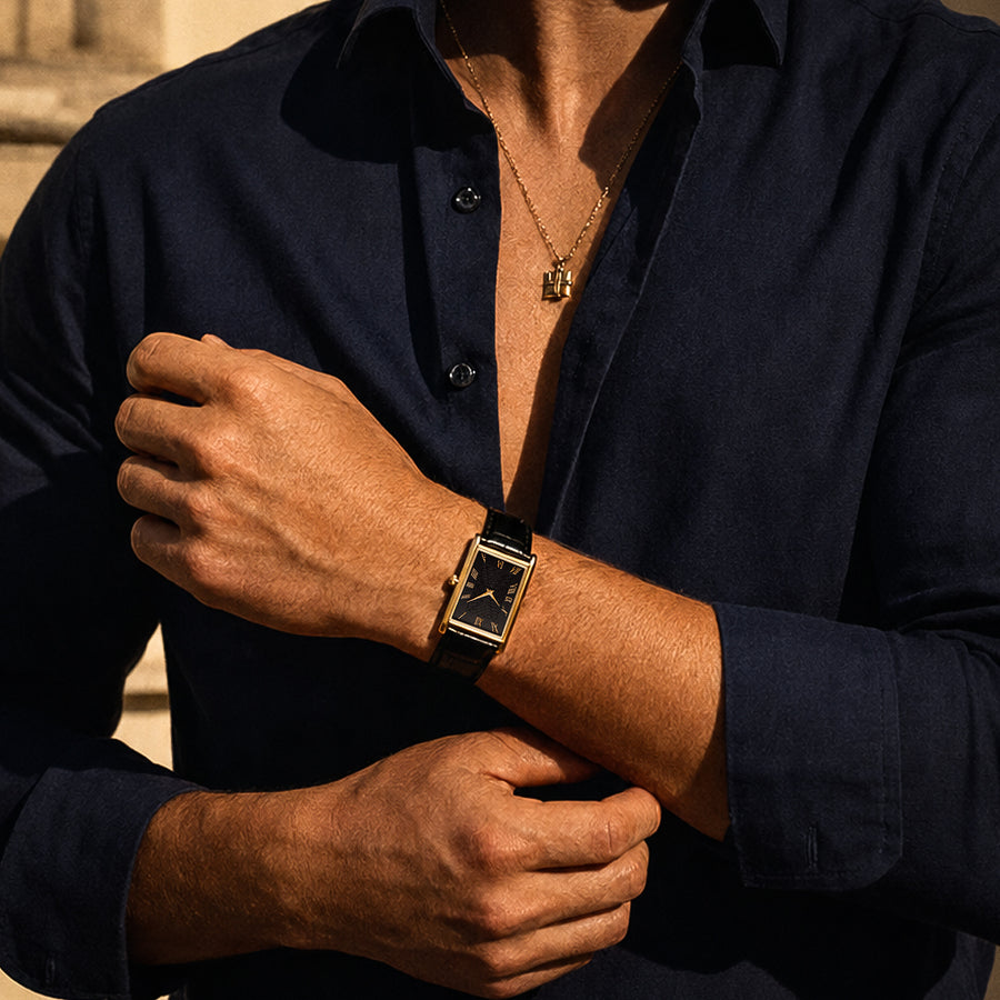 The 1962 gold tank watch worn with an open navy shirt and a gold chain — architectural view